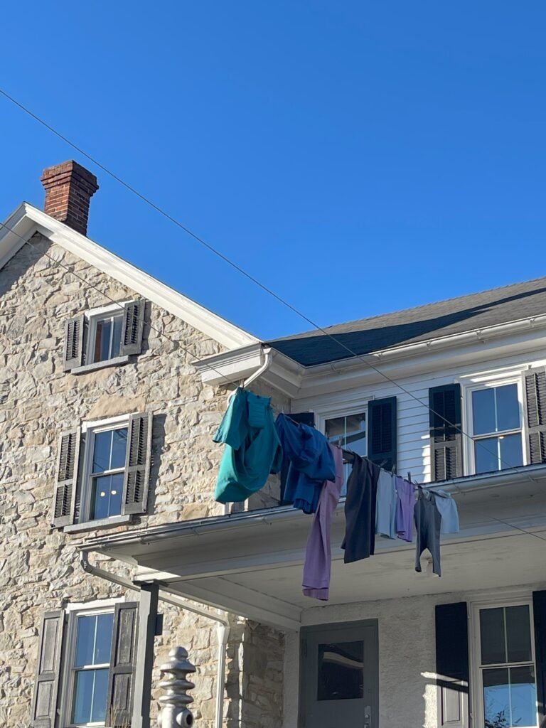 The exterior of The Amish Village shows a clothes line with typical Amish clothing drying.