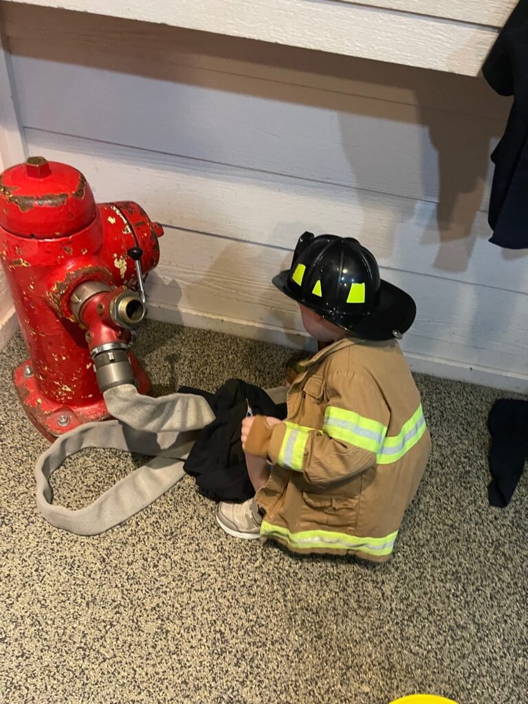 A child wears a firefighter costume while playing at the San Luis Obispo Children's Museum